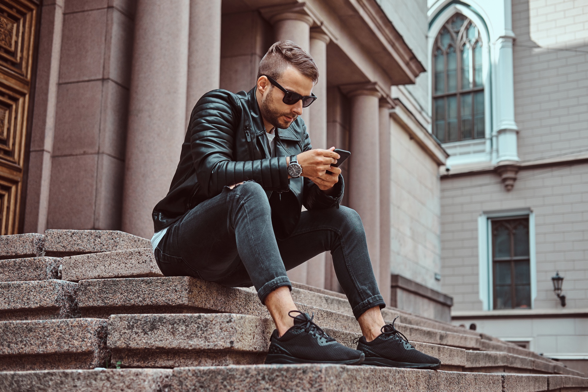 Fashionable guy dressed in a black jacket and jeans
