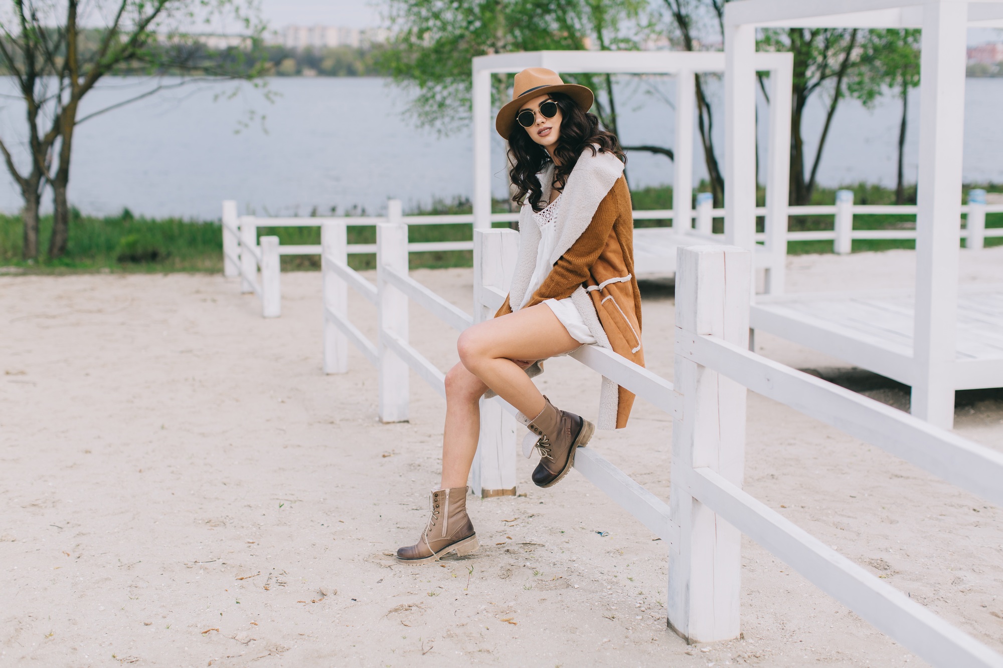 Stylish Young Woman in Casual Chic Outfit Relaxing at Seaside Venue