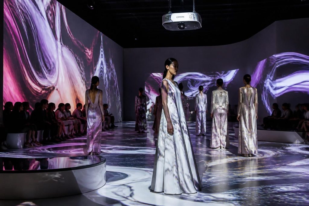 découvrez notre nouvelle collection avec une scénographie immersive innovante grâce aux vidéoprojecteurs epson, offrant une expérience visuelle exceptionnelle et captivante.
